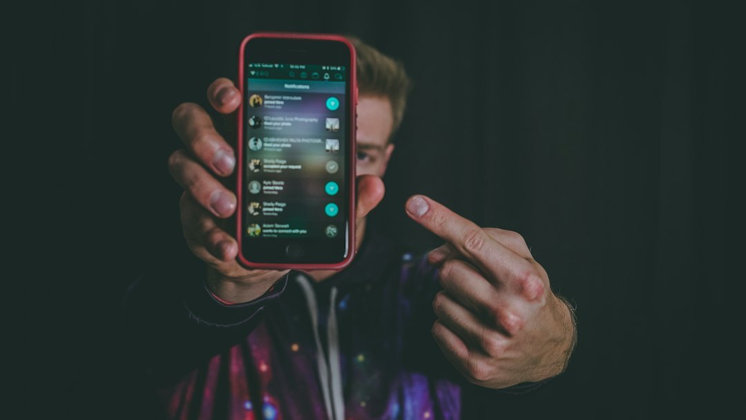 Young man holding a smartphone with a tech app open