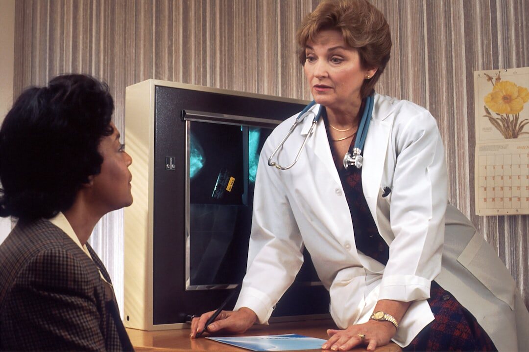 Two colleagues discussing data on a monitor